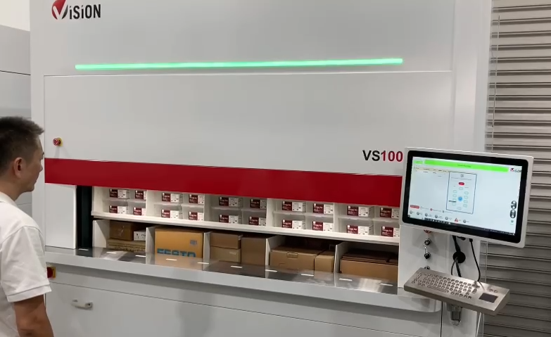 A warehouse worker waits for SKUs to arrive at the window of a vertical carousel storage system